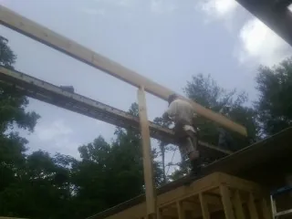 Carpenter setting a ridge beam over a new addition frame — Ice Dam Removal by Roofing Brothers in Archbold