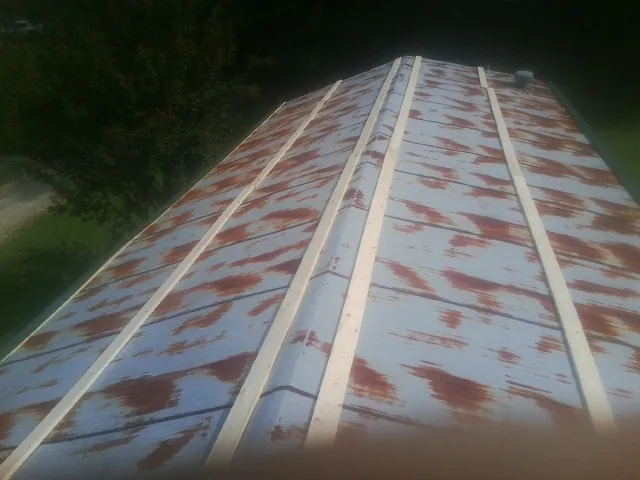 Rusted metal roof panels with new wood purlins before replacement — Storm Damage Roof Repair in Archbold by Roofing Brothers