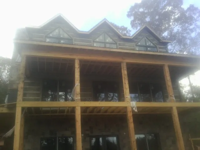 Dormers and porch framing on a large log home under construction — Roof Coating work by our crew in Archbold